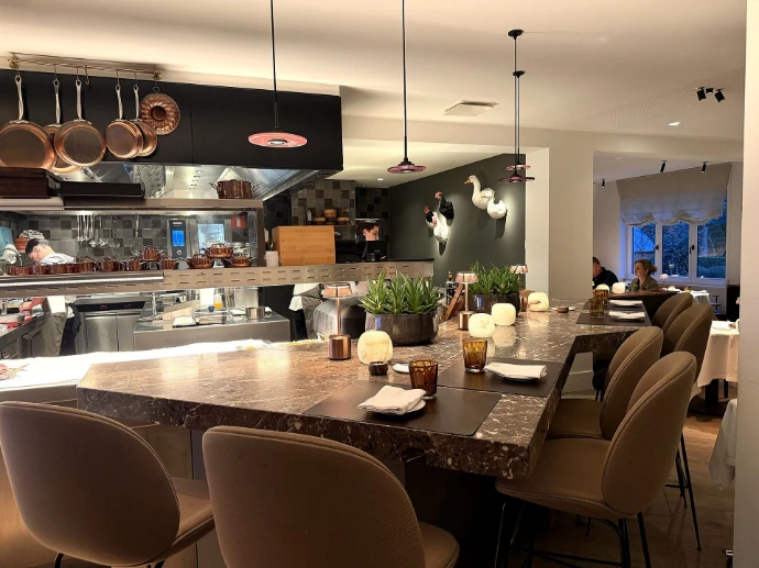 Chef's table aan de marmeren hoge tafel met zicht op de keuken van Brabohoeve